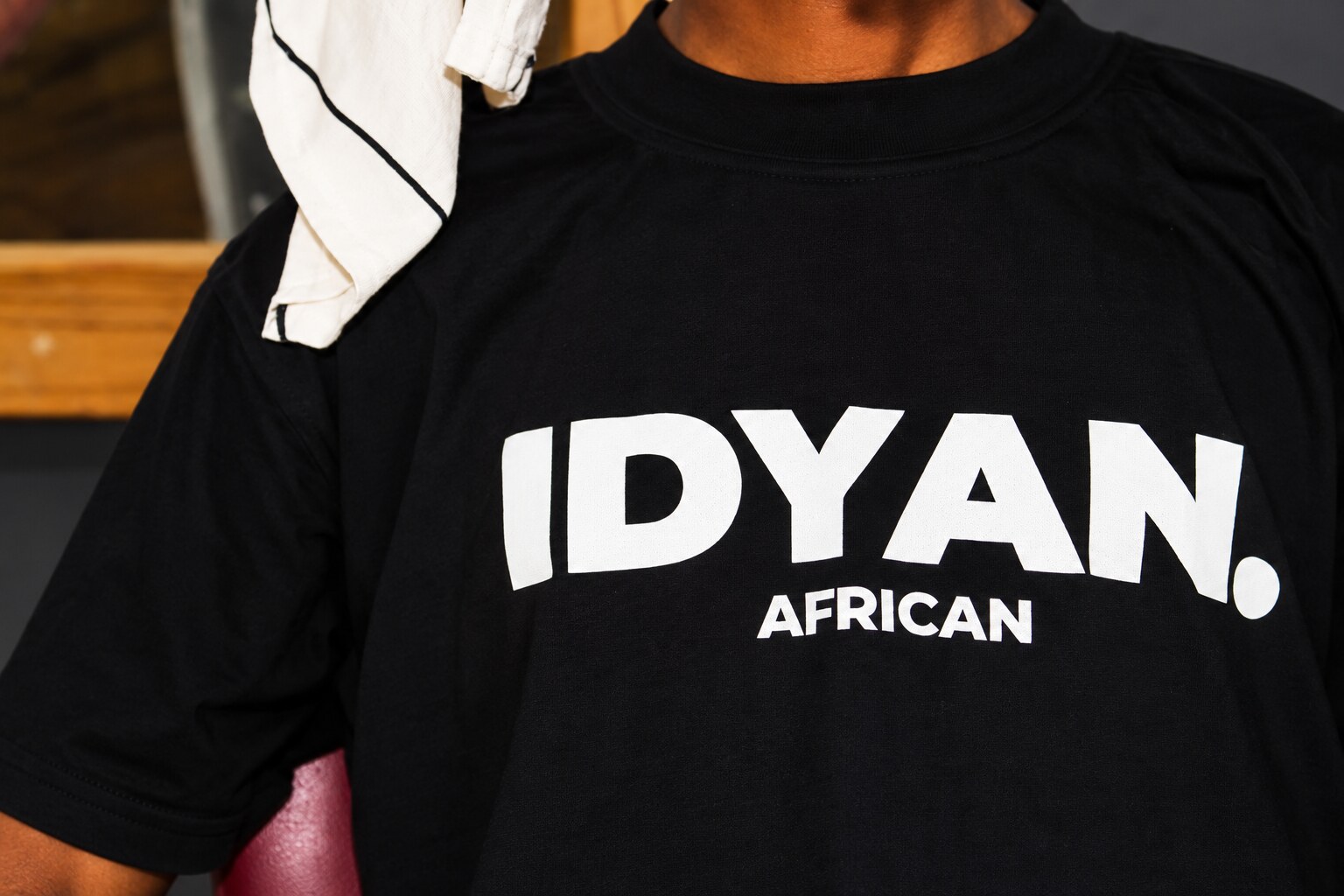 Close-up of the IDYAN. African print on the black tee